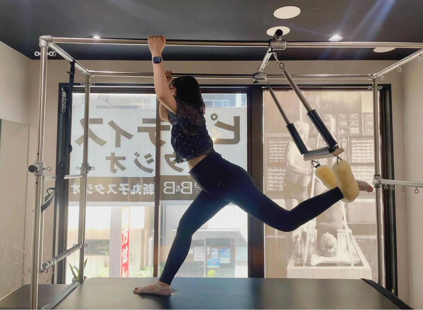 ピラティスタジオBB 武蔵小杉でトラピーズテーブルの上に乗りランジをしているマタニティピラティスを実践している妊婦中期のクライアント写真