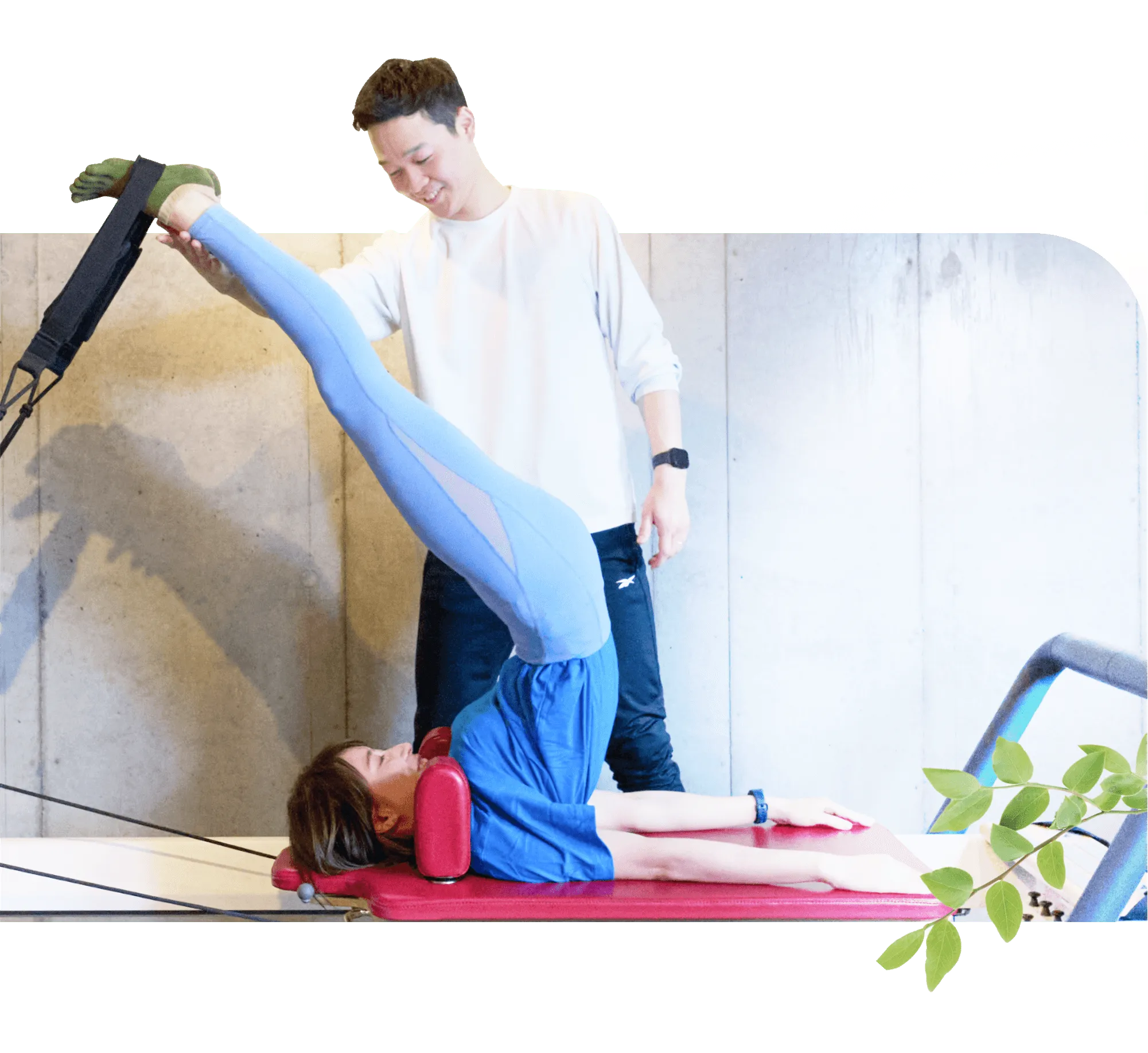 ピラティスを指導する男性とピラティスをする女性の写真