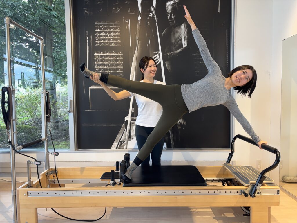 ピラティススタジオBB 仙台泉でリフォーマーを使用してサイドプランクを行っている写真