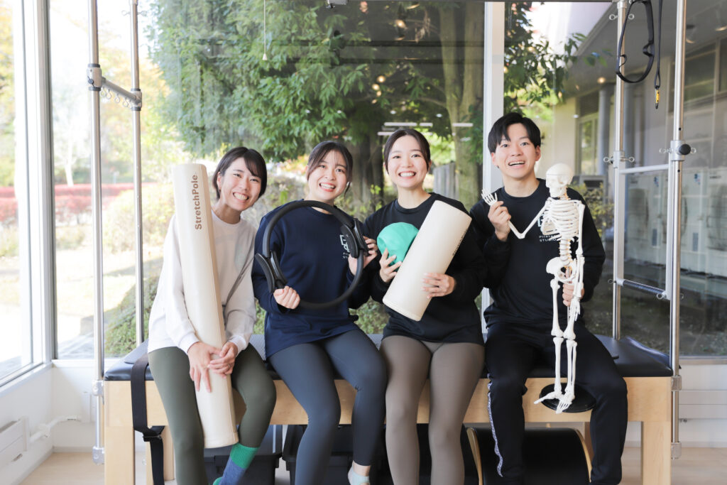 ピラティススタジオBB仙台泉のスタッフ4名がトラピーズテーブルの上で撮影した集合写真