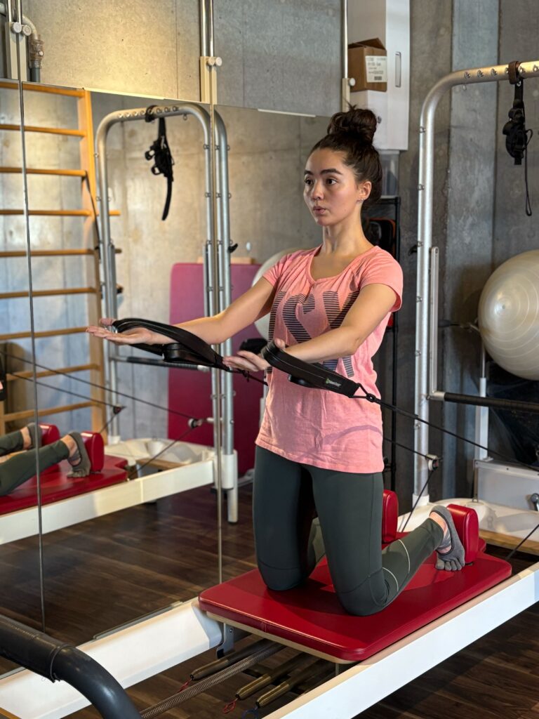 武蔵小杉スタジオの会員様の李フォーマーでピラティスエクササイズのハグツリーをしている様子1