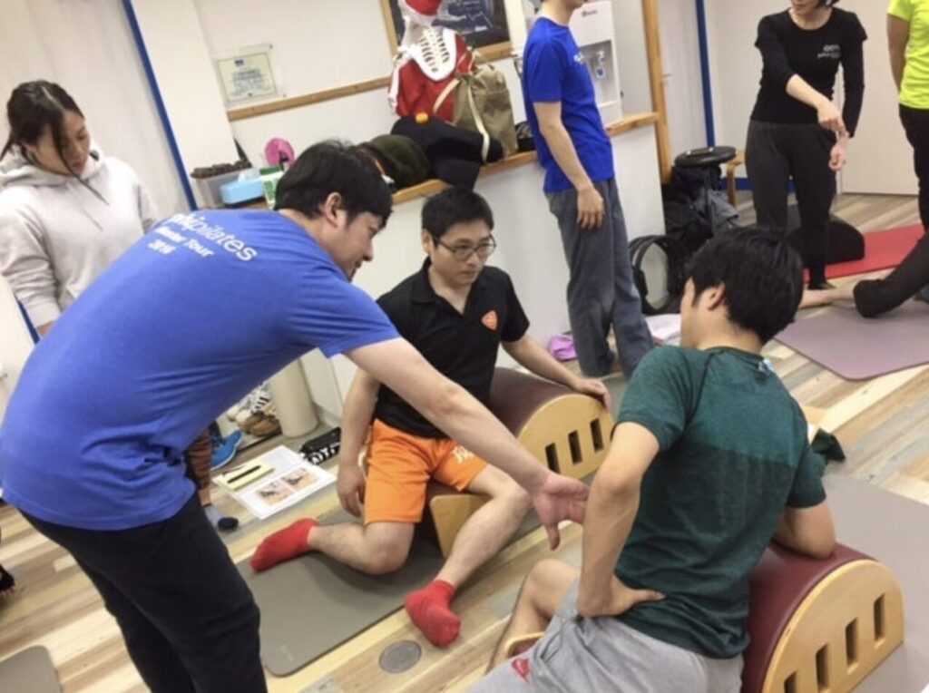 ピラティススタジオBB 田町でPHIピラティスの桑原匠司代表が、バレル養成コースの指導を受講生向けに実施している写真