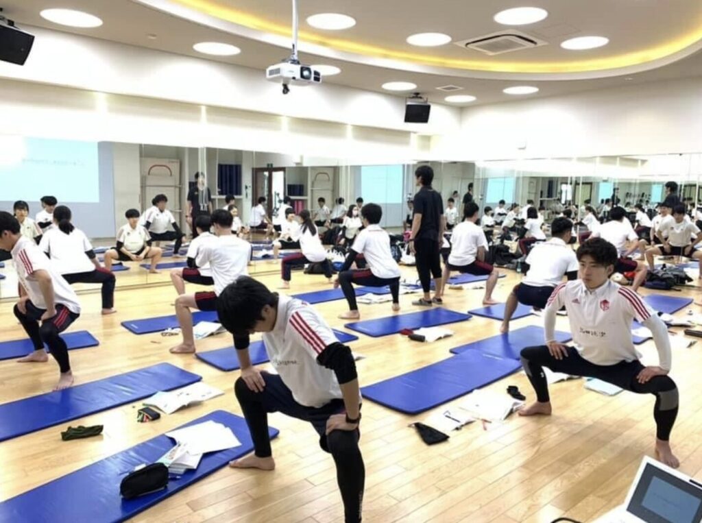 ピラティススタジオBBのスタッフが、スポーツ専門学校の生徒100名に対してピラティス指導をしている2019年当時の写真