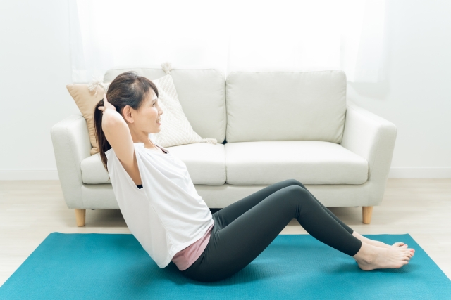 自宅でピラティスの基本ポーズを実践しようとしている女性
