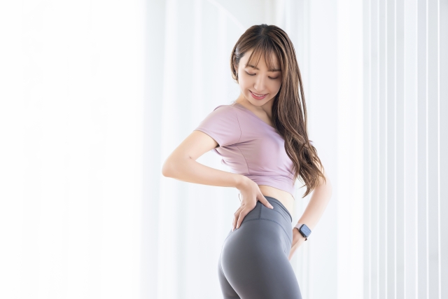 ウォールピラティスで姿勢改善し、健康的な体幹を持つ笑顔の女性