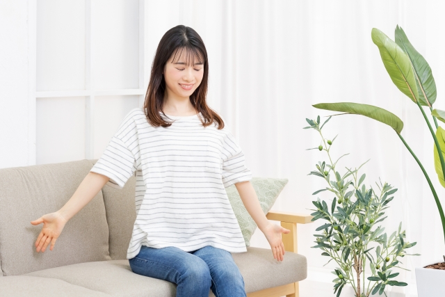 リラックスしながらピラティスの呼吸法を自宅で練習している女性