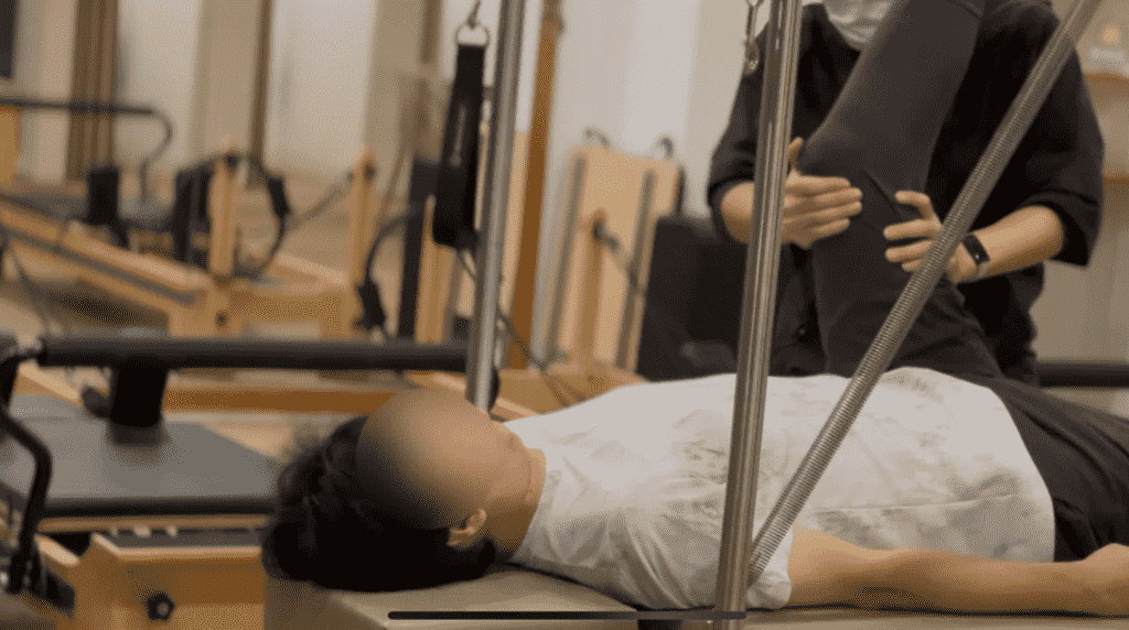 40代男性が、ピラティススタジオBB 肥後橋でピラティスを受けている写真